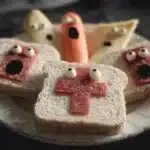 Plate of spooky Halloween snacks including cupcakes, cookies, and candy