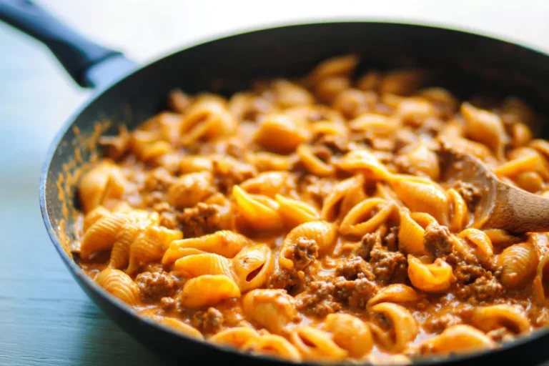 Creamy beef and shells dish garnished with herbs