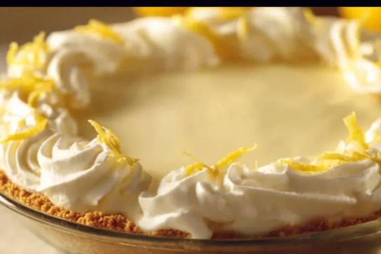 Sliced Limoncello Cream Pie topped with whipped cream and lemon zest
