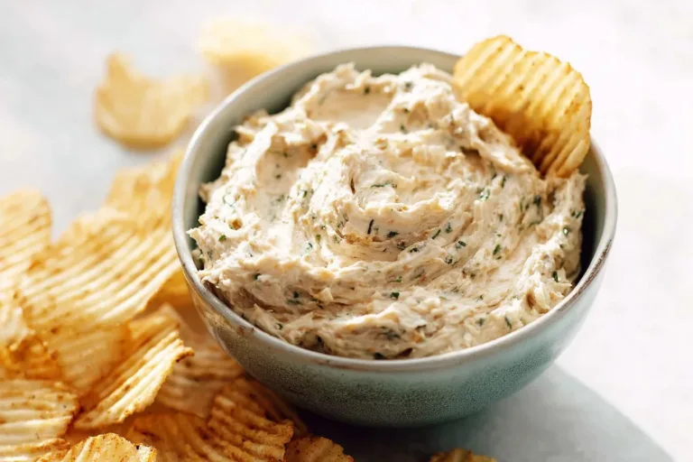 Delicious caramelized onion dip served with fresh vegetables and chips.