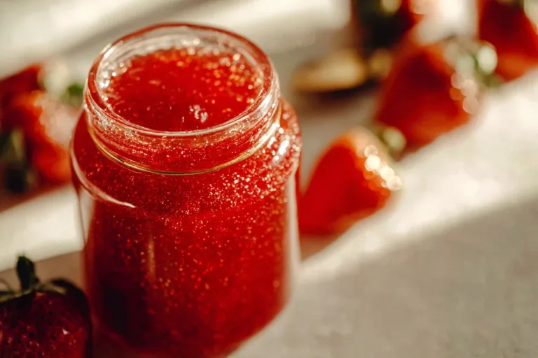 Homemade strawberry sauce drizzled over vanilla ice cream