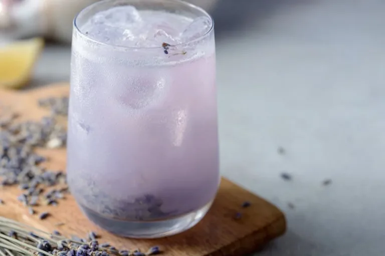 Refreshing Coconut Lavender Lemonade in a glass with lavender sprigs and coconut slices.
