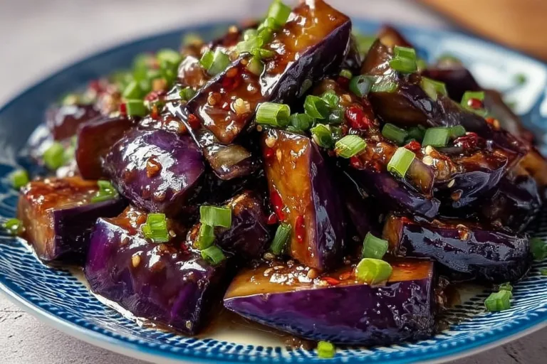 Garlic caramelized eggplant dish showcasing savory flavors and garnishes.