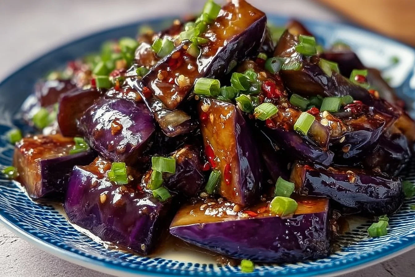 Garlic caramelized eggplant dish showcasing savory flavors and garnishes.