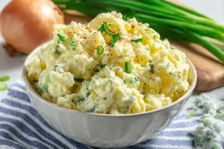 Bowl of old-fashioned potato salad with vegetables, perfect for gatherings.