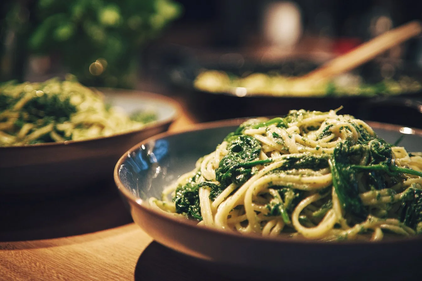 Creamy spinach pasta dish served in a bowl with a sprinkle of cheese