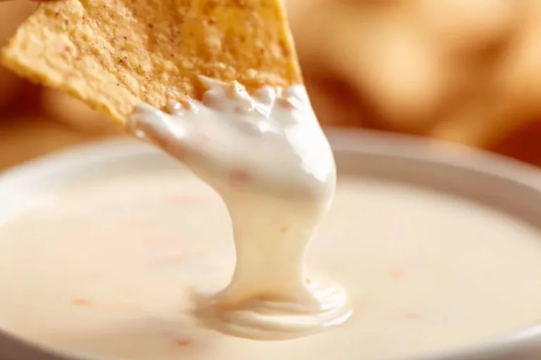 Creamy Mexican white cheese dip served with tortilla chips and garnished.