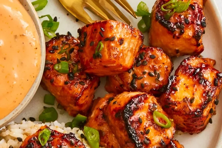 Air fryer salmon bites served with bang bang sauce on a plate.
