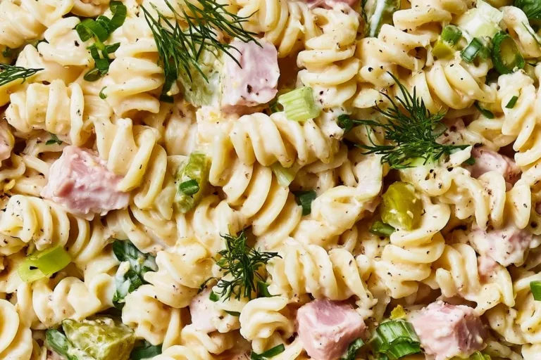 Ham and pickle pasta salad served in a bowl with fresh ingredients
